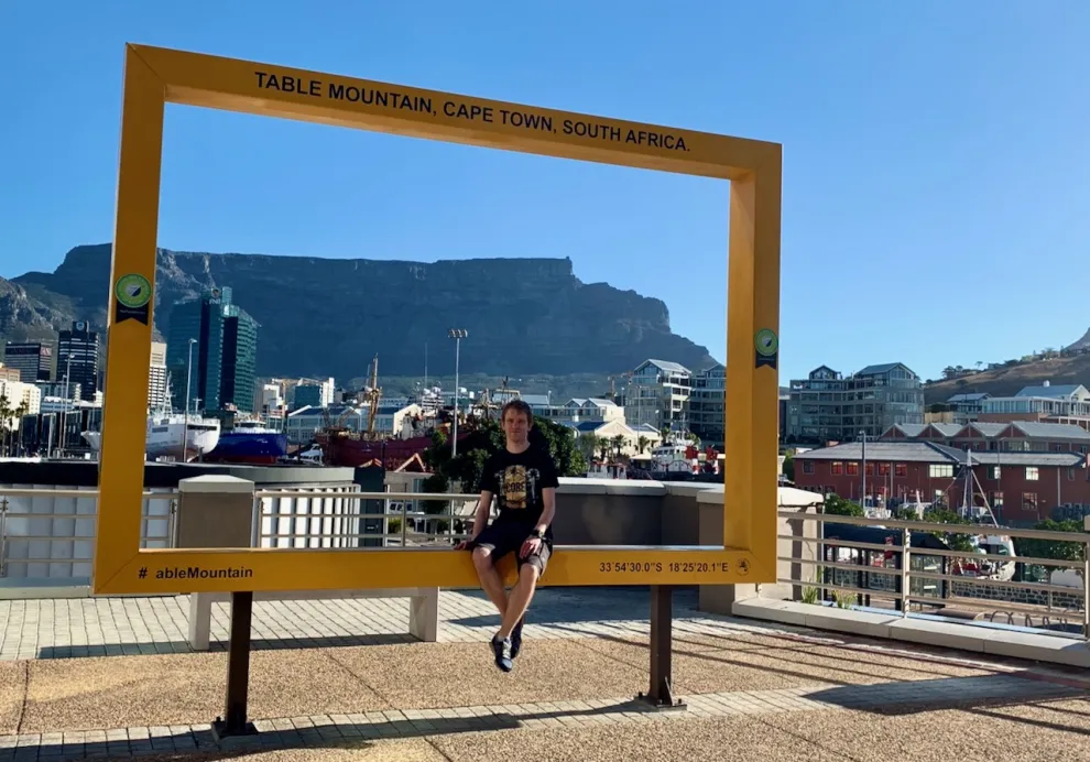 Christian vor einem Schild mit der Aufschrift "Table Mountain, Cape Town, South Afrika" in Kapstadt, Südafrika